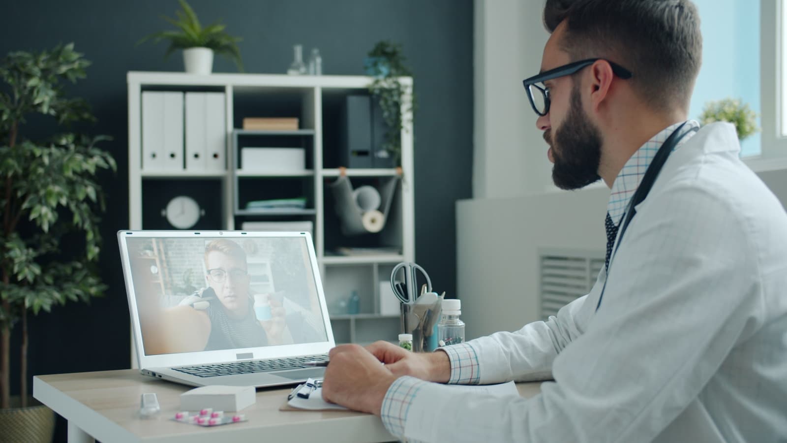 A healthcare provider reviewing a virtual visit on a laptop