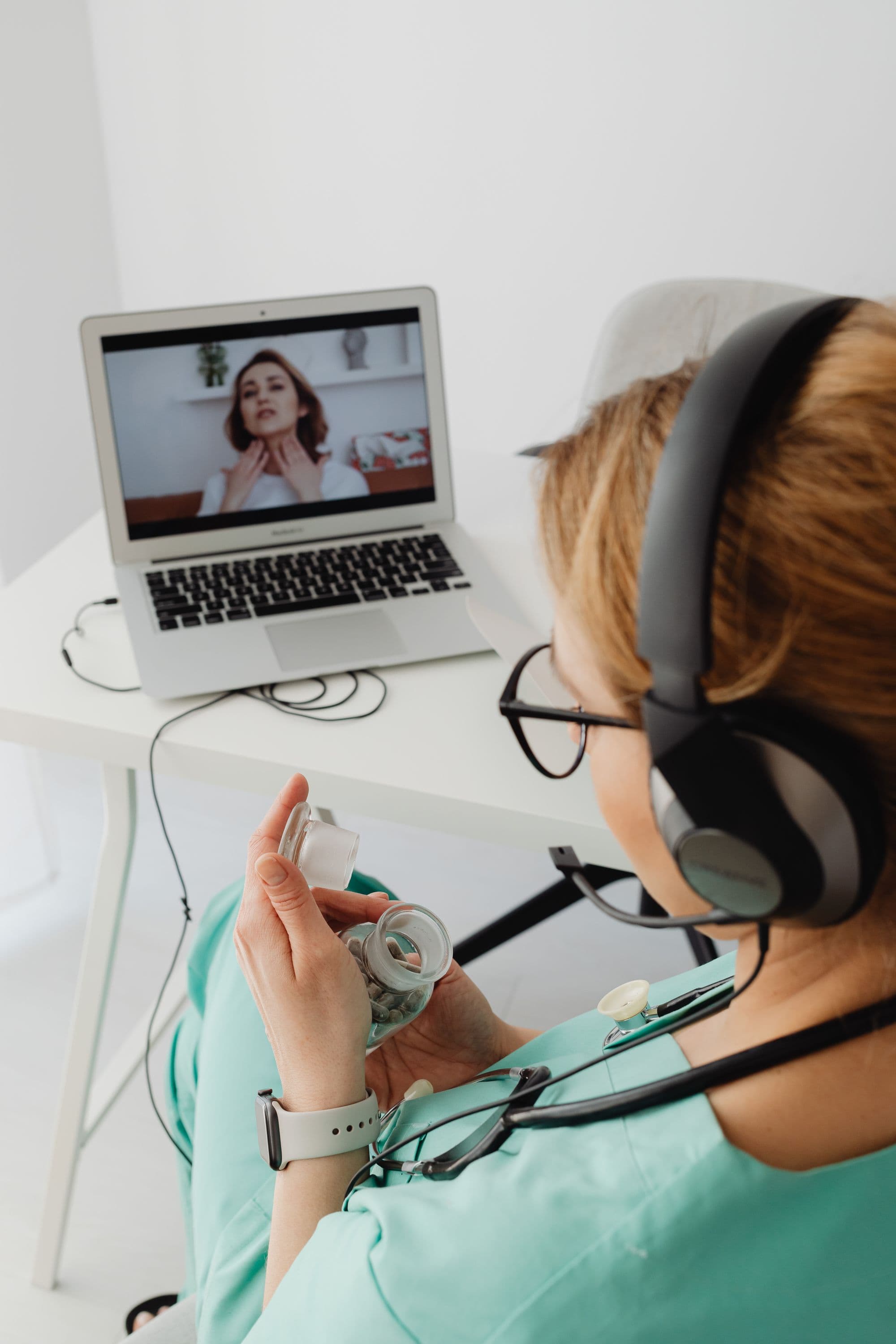 A healthcare provider on a video call with a patient, visible on the laptop screen, during a virtual visit